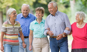 Five older adults walking together outside