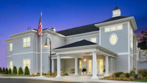 Exterior of Duxbury House Memory Care Residence lit up at night