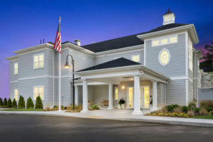 Exterior of Duxbury House Memory Care Residence lit up at night