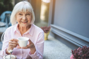 Smiling older woman drinking a cup of coffee